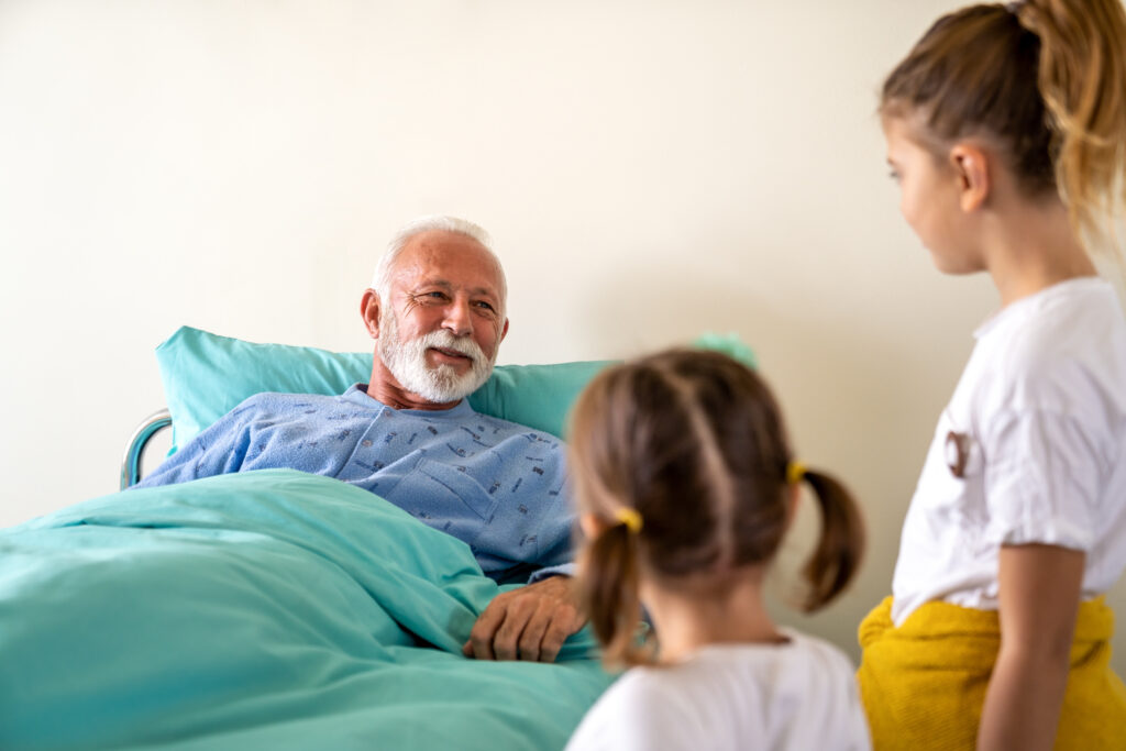 Happy senior man is recovering from the coronavirus is visited by his grandchildren